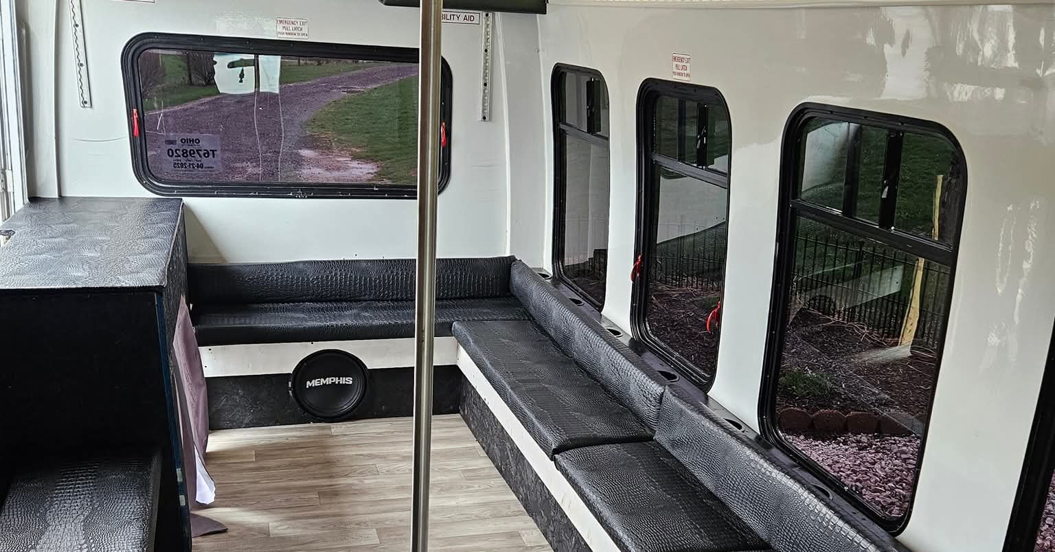 Daytime interior view of the party bus with leather seats and dance pole