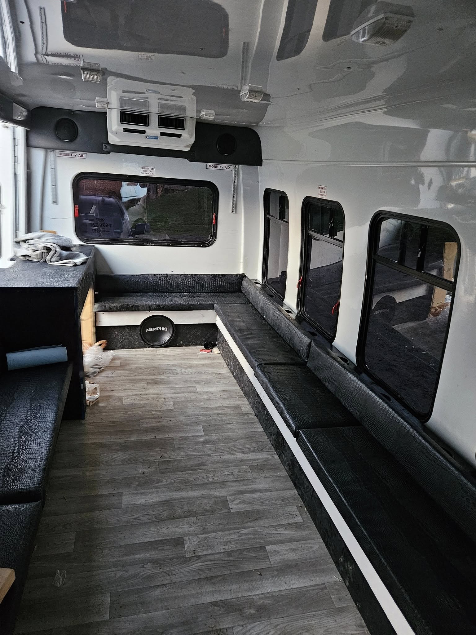 Wide interior shot showing leather wraparound seating, sound system, and storage area